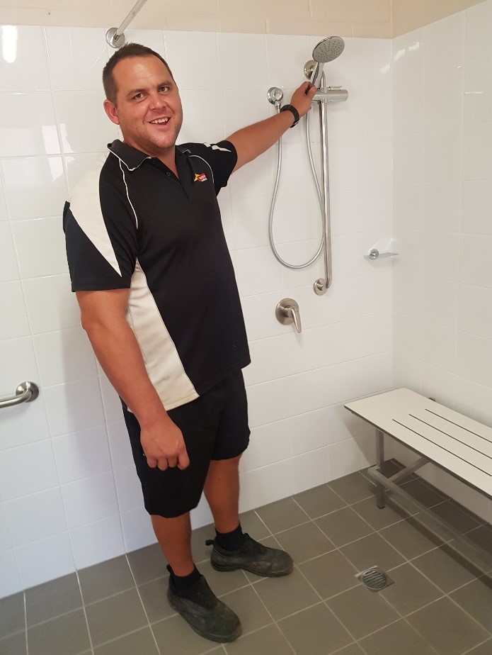 Tangentyere Constructions Assistant Manager Bradley Parsons shows off a newly installed access bathroom in one of the two upgraded homes.